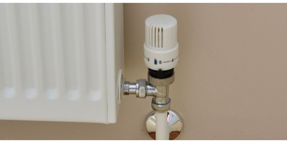 pair of hands adjusting a thermostatic radiator valve