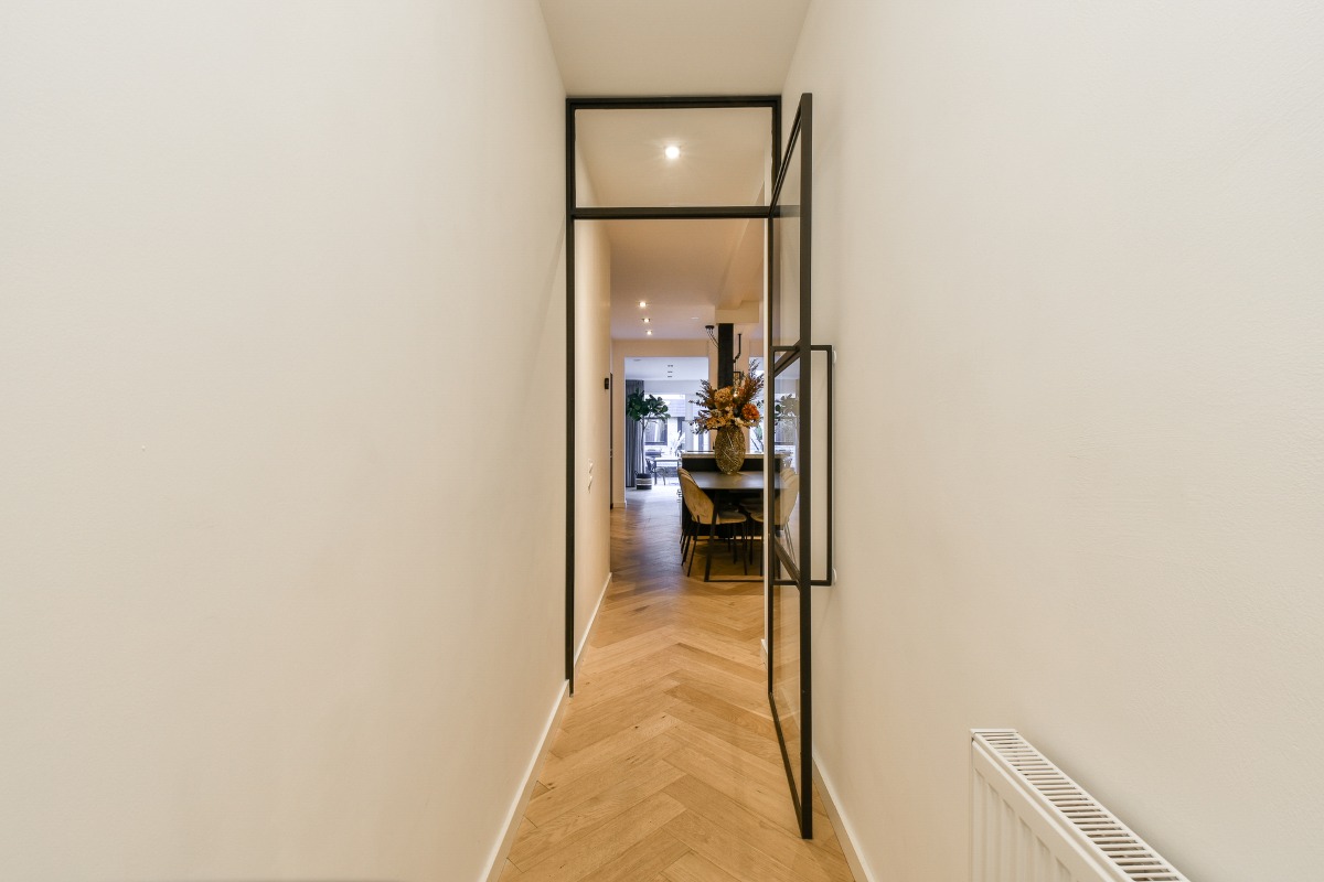 A hallway with a glass door and a radiator A hallway with a glass door and a radiator