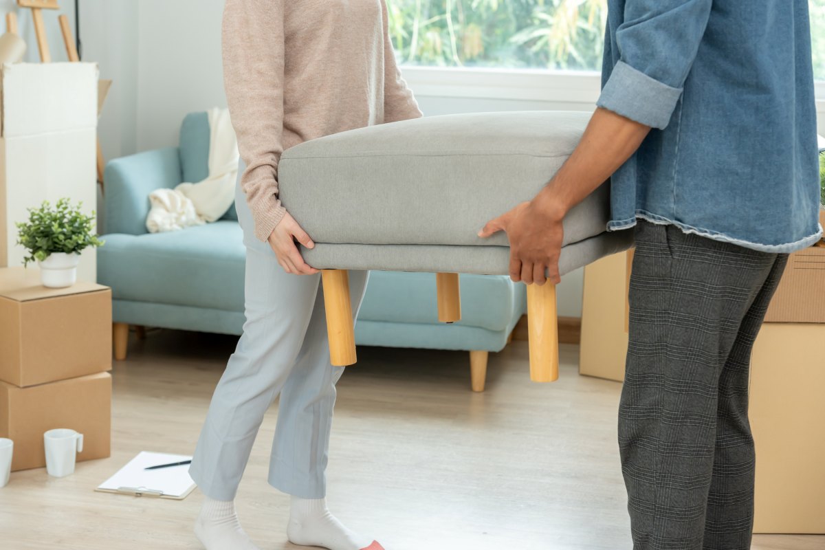 two person moving furnitures to make space